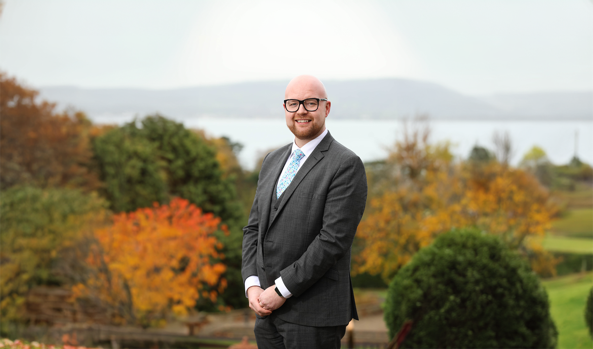 Scott Weatherup, from Hastings Hotels poses in front of a autumnal landscape.