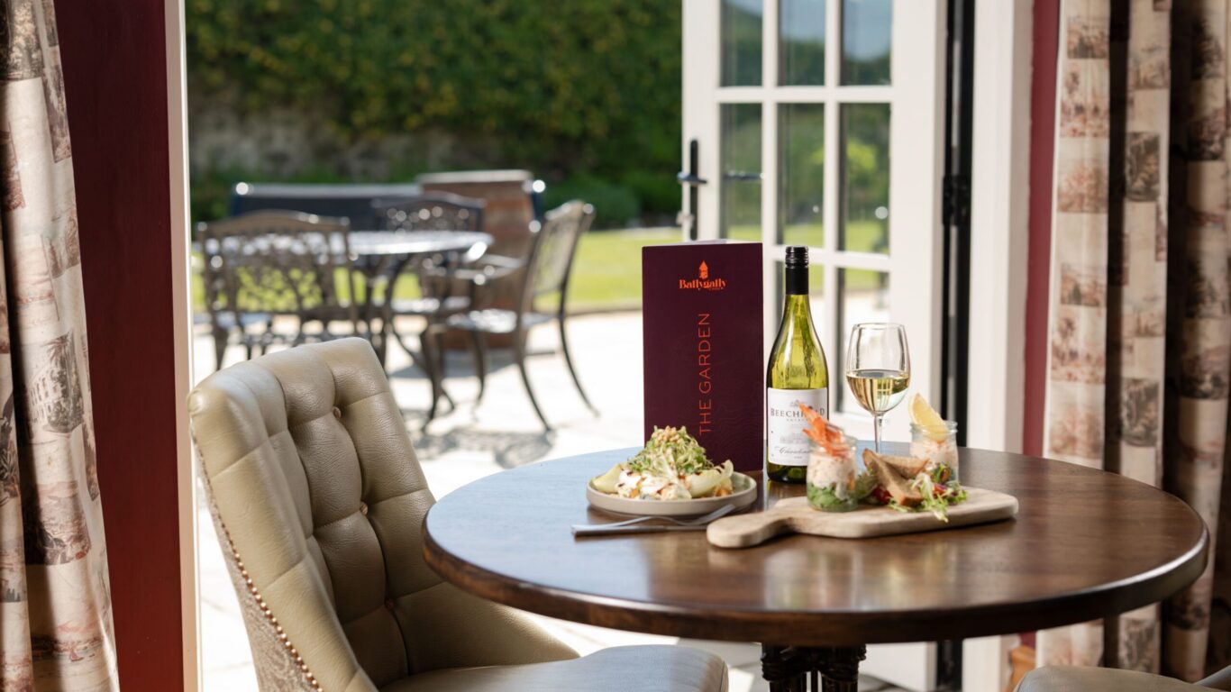 Elegant dining with garden view, featuring delicious cuisine, wine, and outdoor seating at luxury hotel restaurant.
