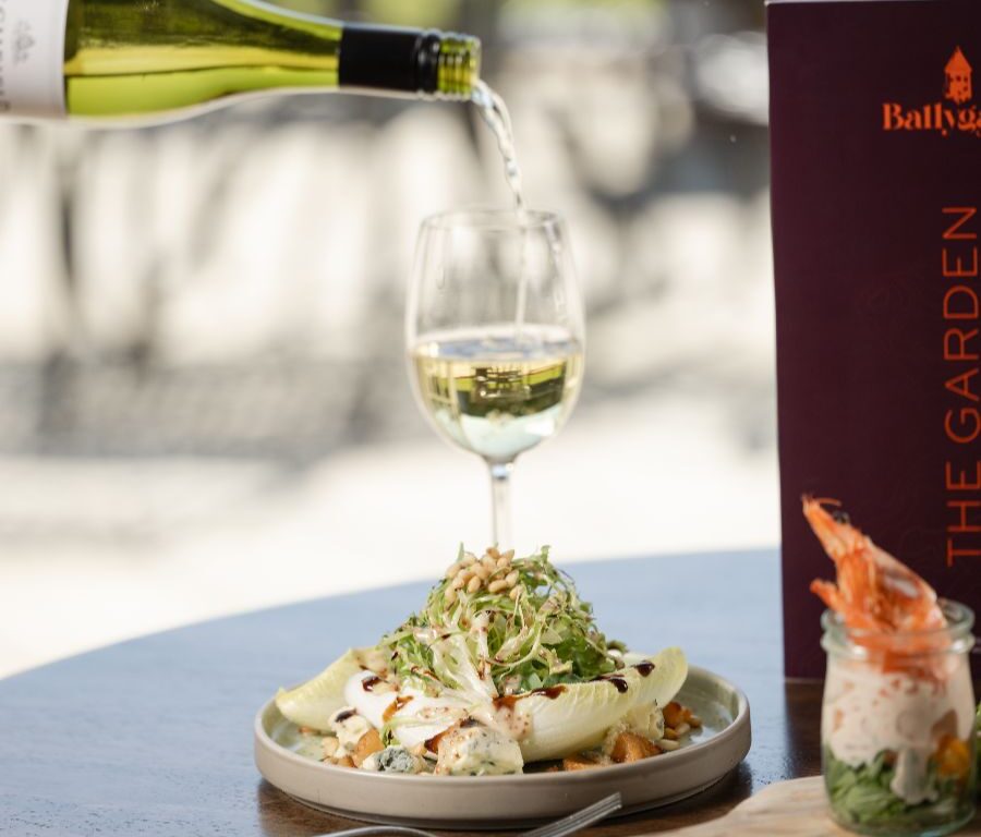 Enjoy a fresh salad with wine and prawn cocktail at an elegant hotel restaurant, perfect for a gourmet dining experience.