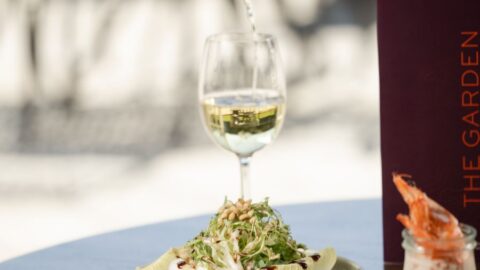 Enjoy a fresh salad with wine and prawn cocktail at an elegant hotel restaurant, perfect for a gourmet dining experience.